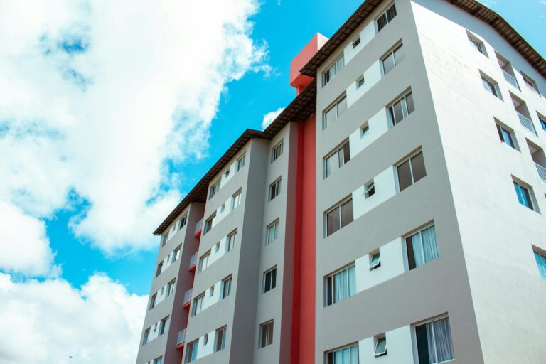 High-rise residential building under blue skies, showcasing modern architecture.