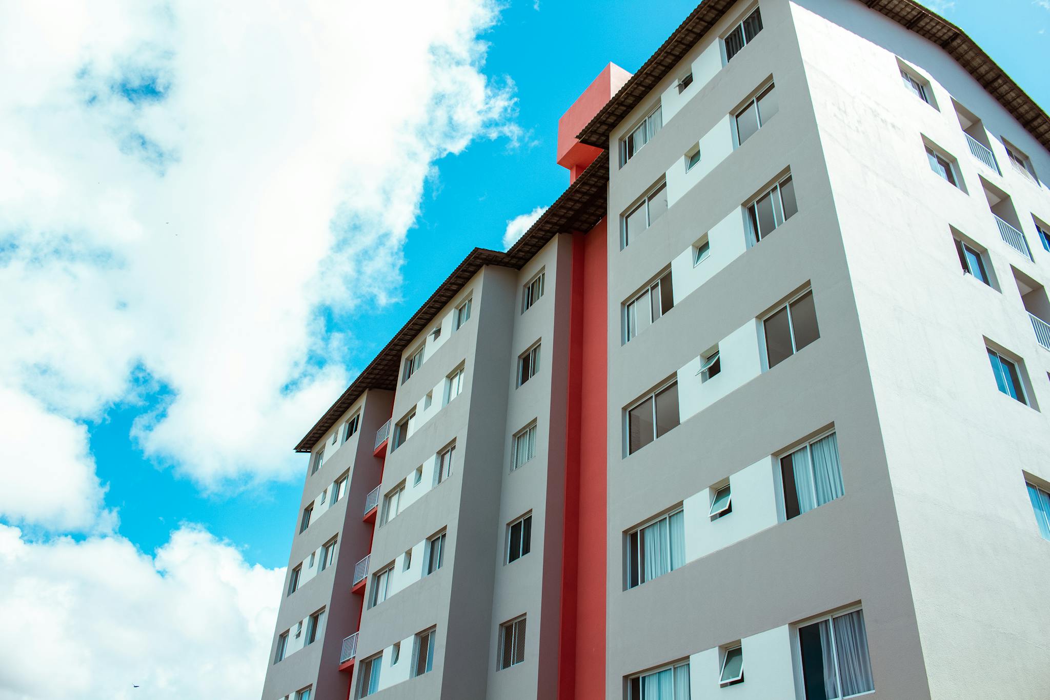 High-rise residential building under blue skies, showcasing modern architecture.